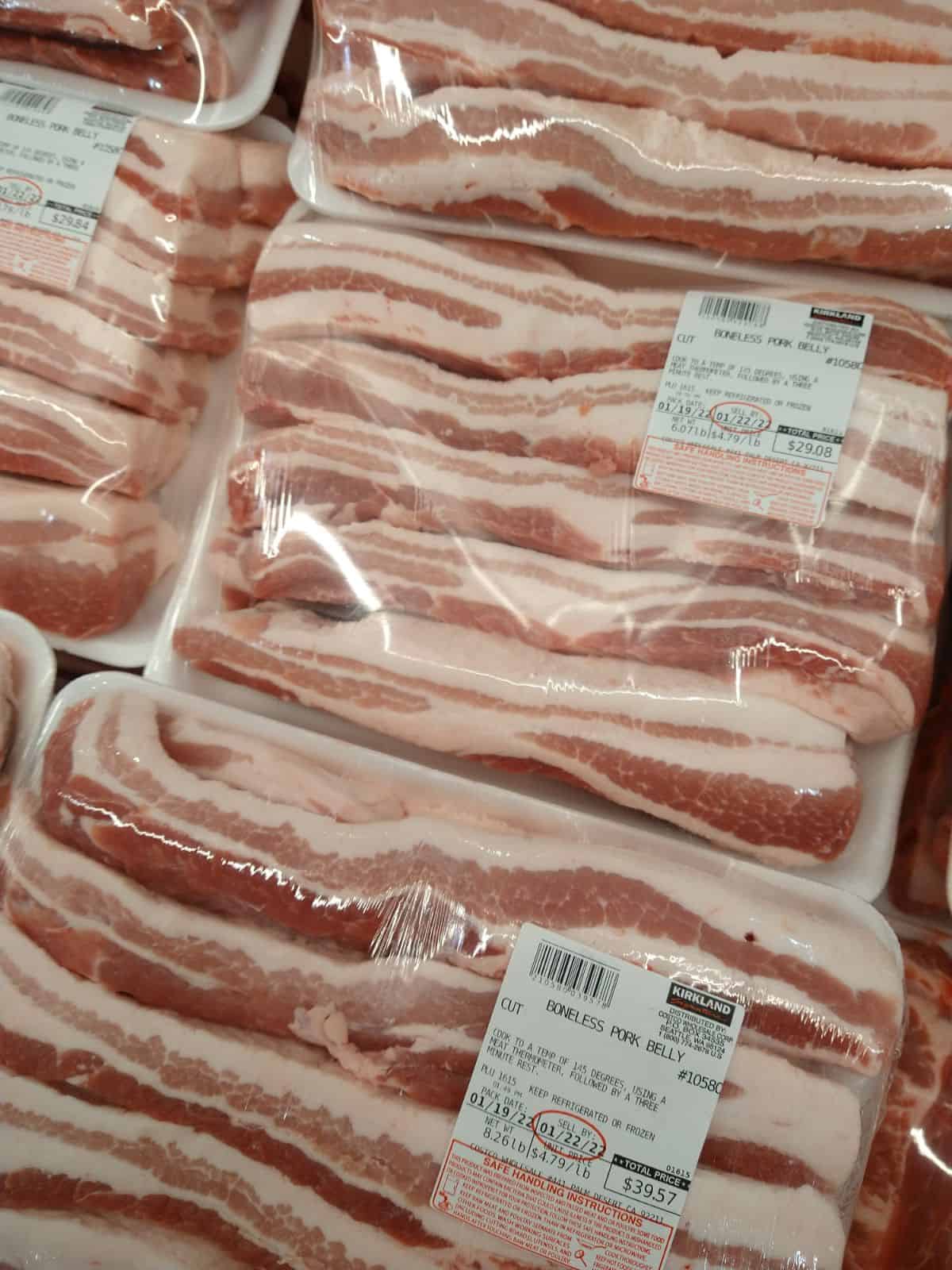 Kirkland packaged boneless pork belly on display at Costco. the sticker says the cost is $4.79/lb.