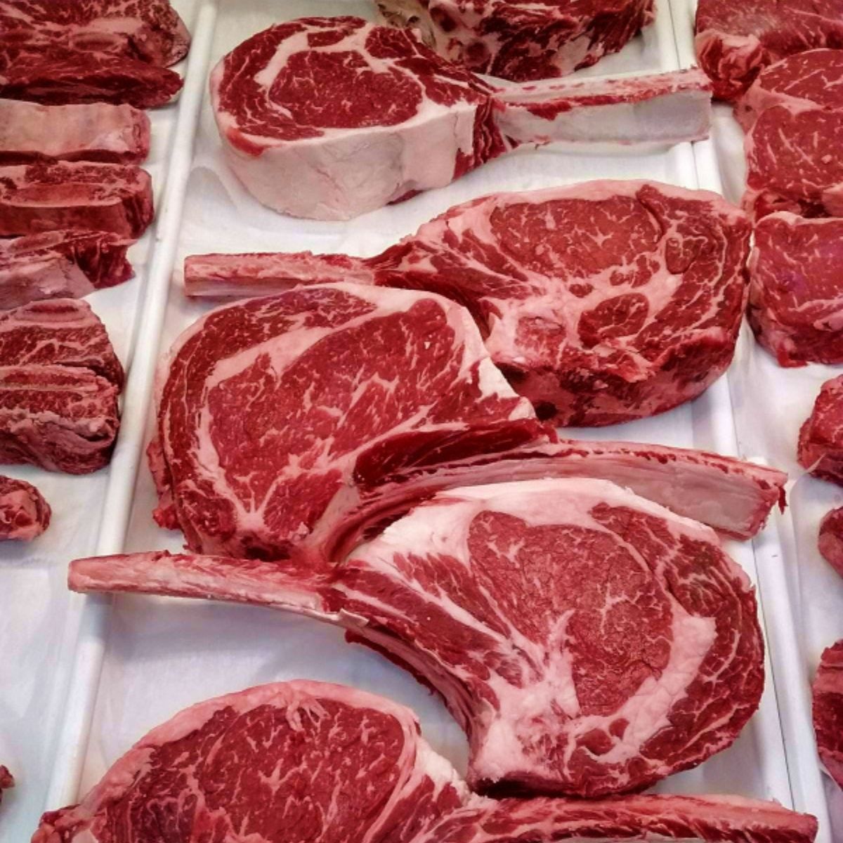 Ribeye steaks with long bones on display at a Costco store.