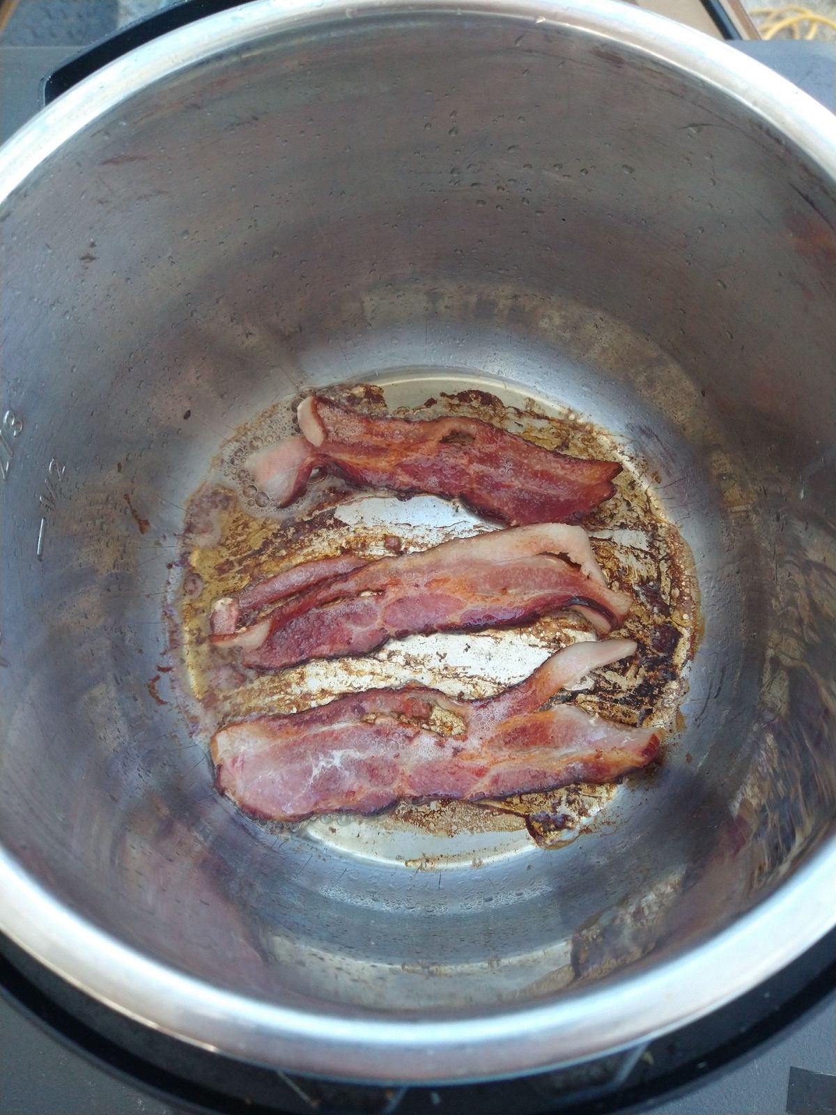 Cooked bacon in the bottom of the Instant Pot.