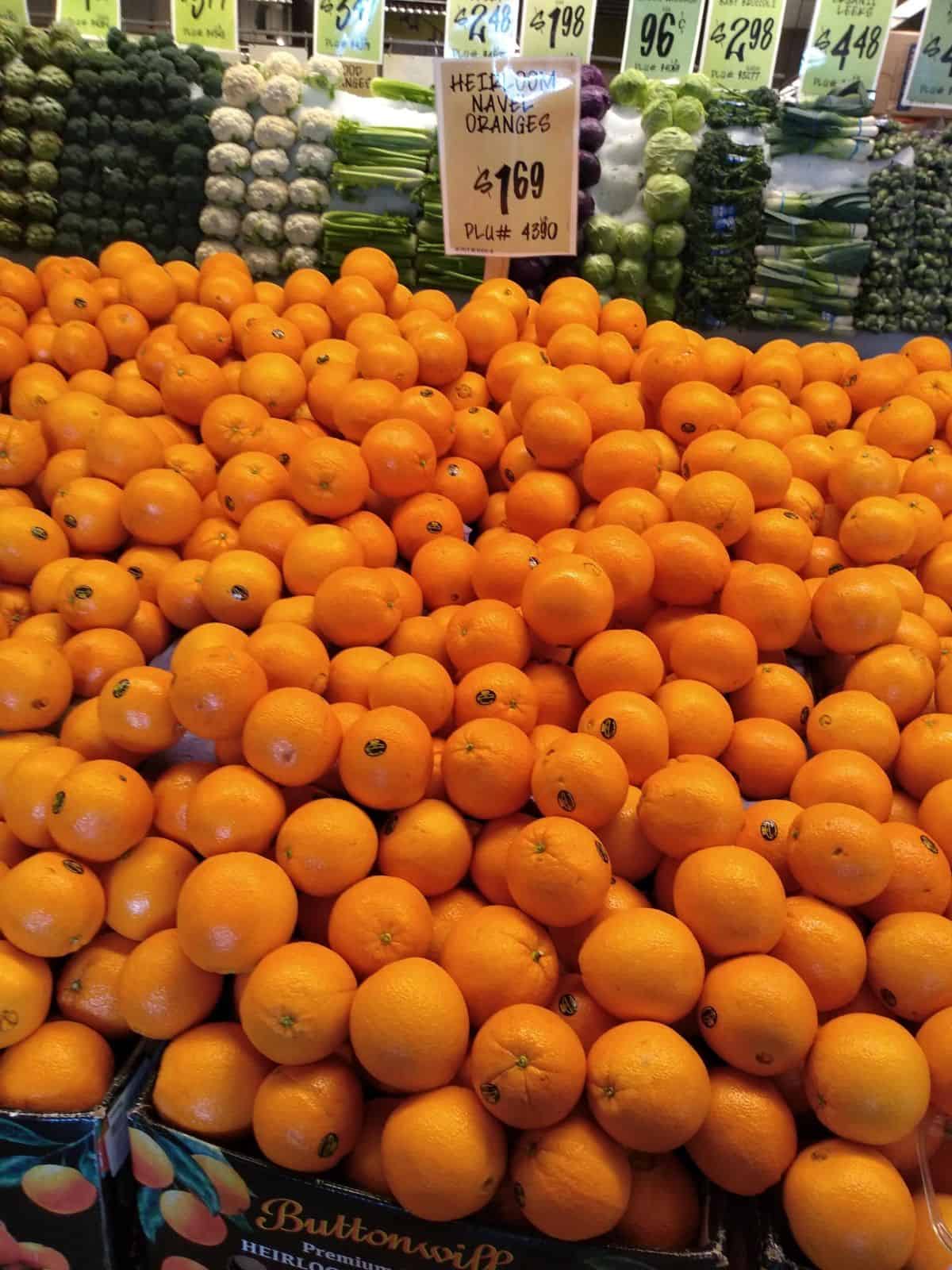 A big grocery store display of Heirloom navel oranges pilled high.