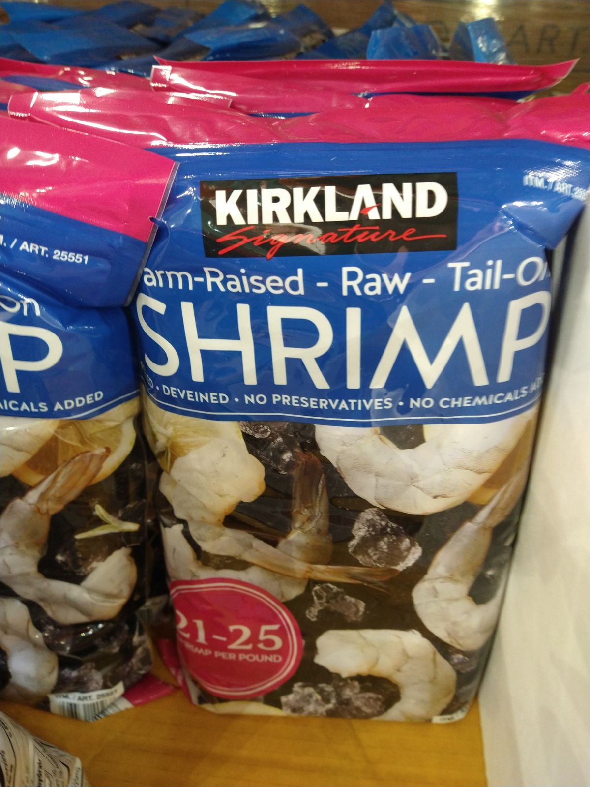 A close up a of blue bag of Kirkland Farm-Raised Raw Tail-On shrimp.