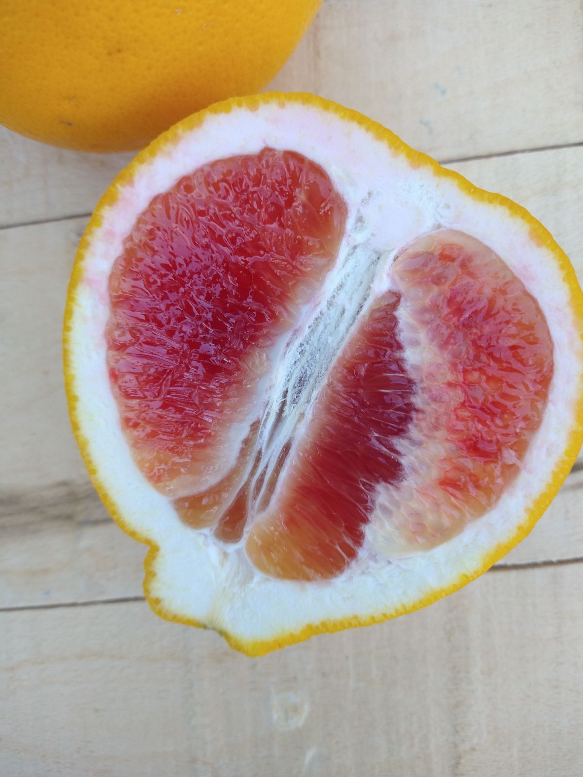 A sliced up Valentine Pomelo showing it's red flesh.