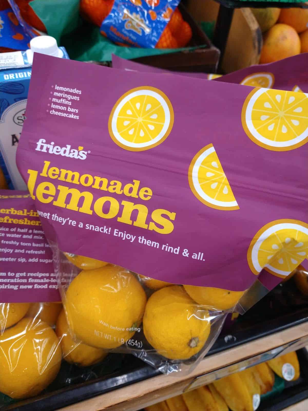 Bags of Frieda's Lemonade Lemons on display at a grocery store.
