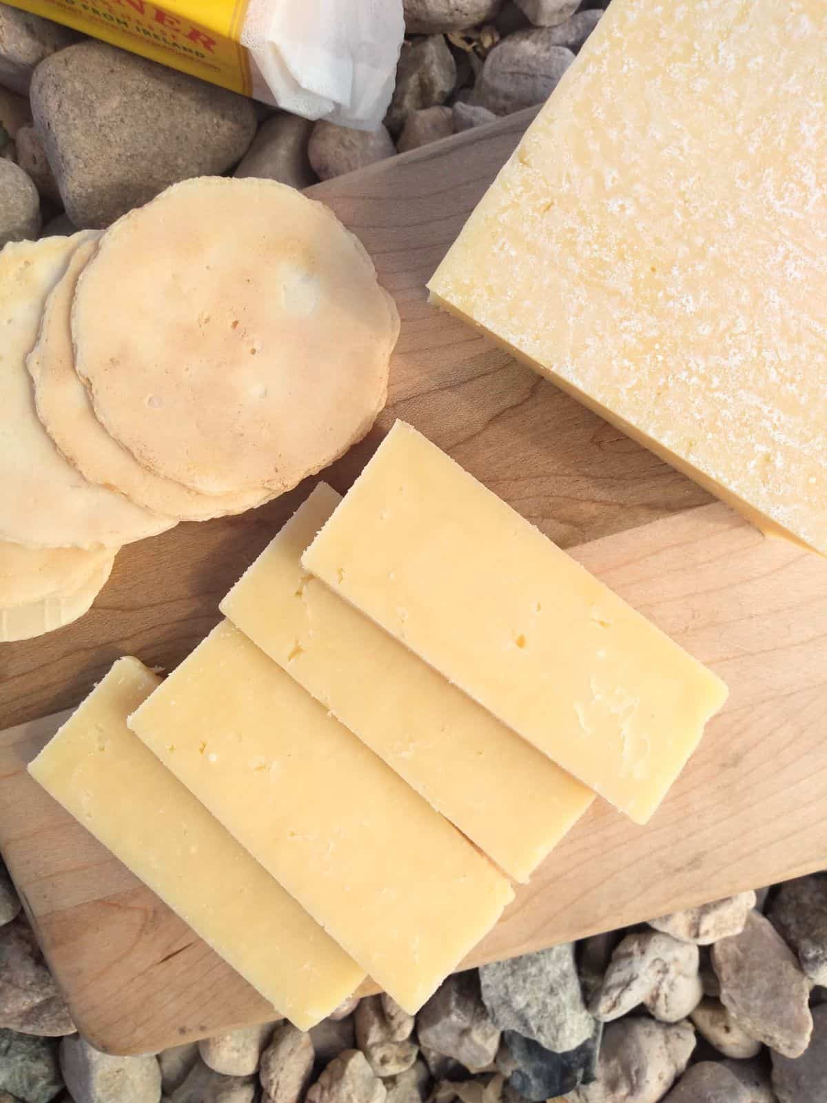 A close up showing the texture of the Dubliner cheese. It's appearance is similar to cheddar. You can see some white crystals on the biggest piece of cheese.