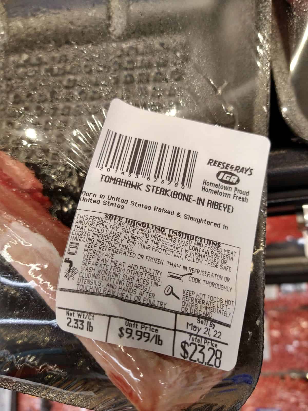 A close up of the label of a Tomahawk steak (bone-in ribeye). The weight is 2.33 lb. The unit price is $9.99/lb and the total price is $23.28.