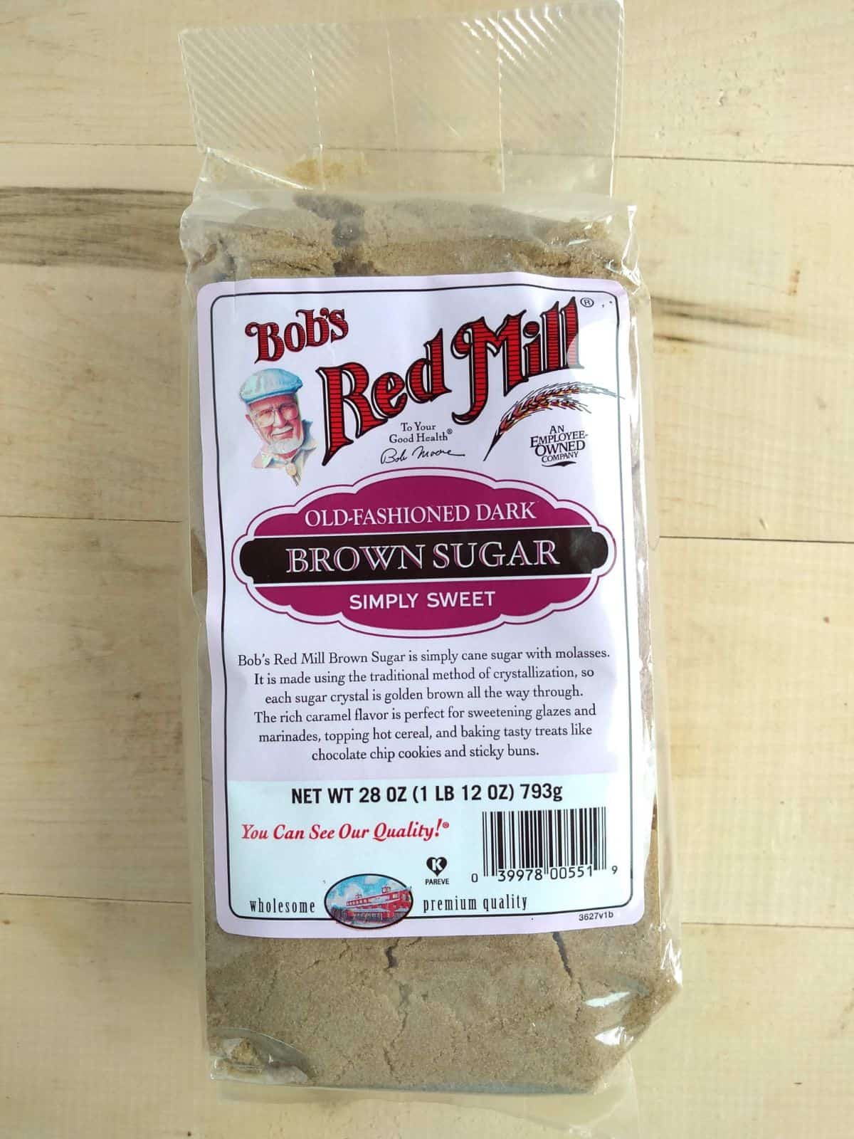 A bag of Bob's Red Mill Old Fashioned Dark Brown Sugar sitting on a wood board.