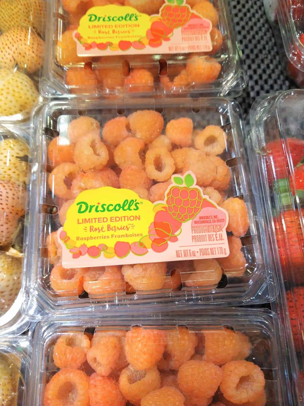 Driscoll's Rose Strawberries in containers at the grocery store next to other berries.