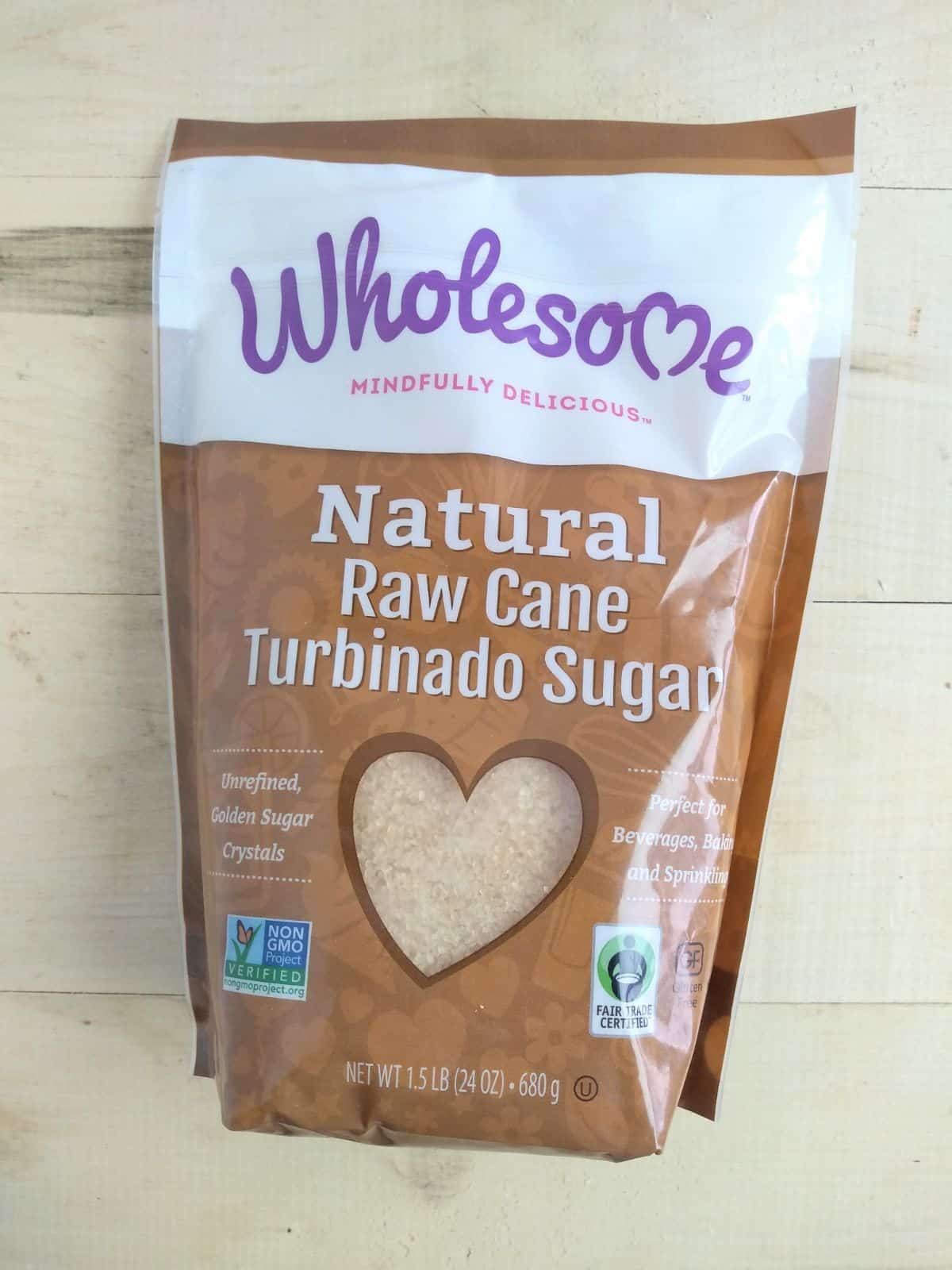 A bag of Wholesome Natural Raw Cane Turbinado Sugar sitting on a wood board.
