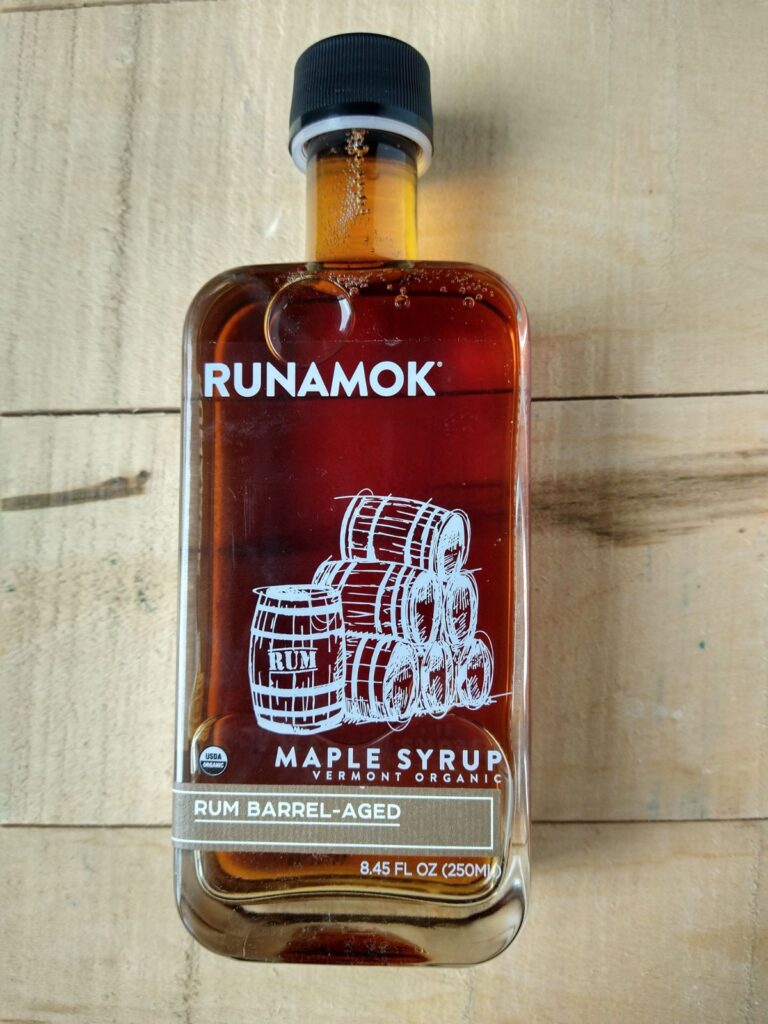 Runamok Rum barrel aged syrups on a wood board. 