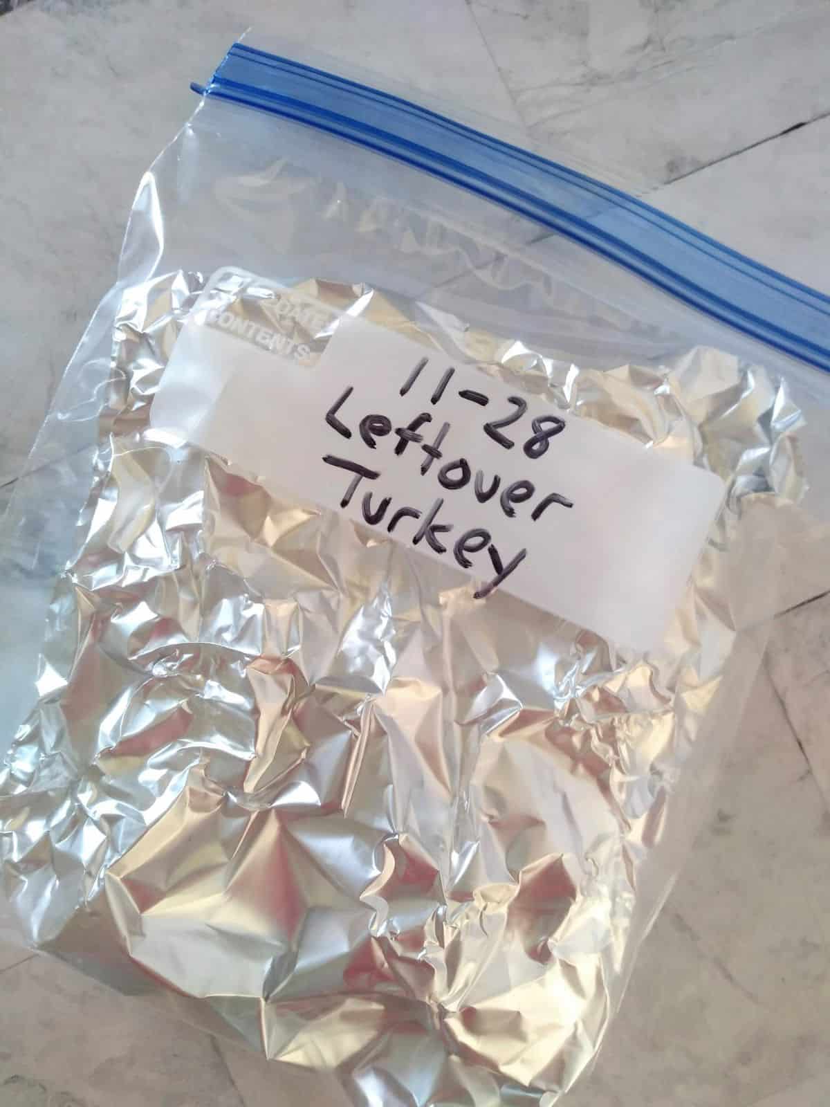 A bag of foil wrapped leftover turkey that is dated 11-28.