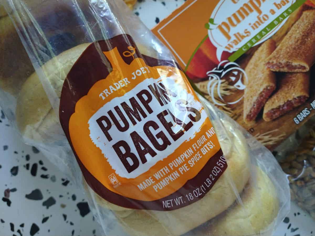 A bag of Trader Joe's pumpkin bagels. 6 bagels are in the bag. The bagels are made with pumpkin flour and pumpkin pie spice bites. 