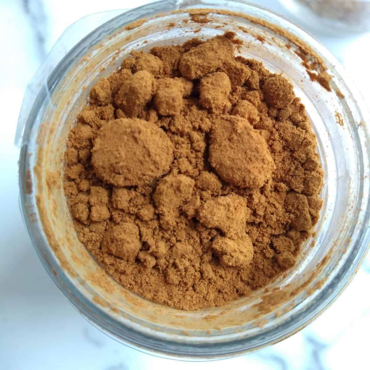 A close up of an open jar of cinnamon.