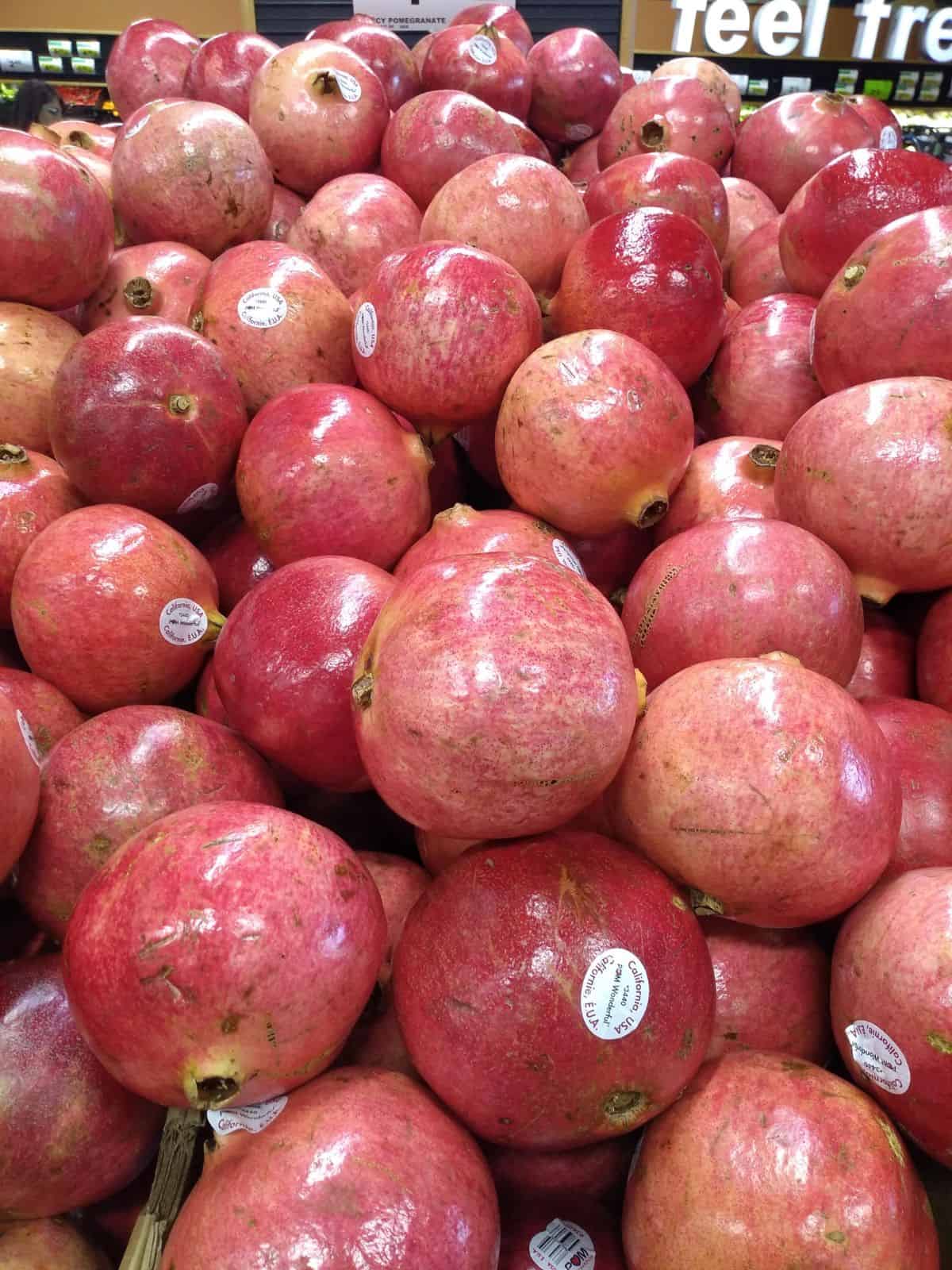 A pile of pomegranates at the grocery store.