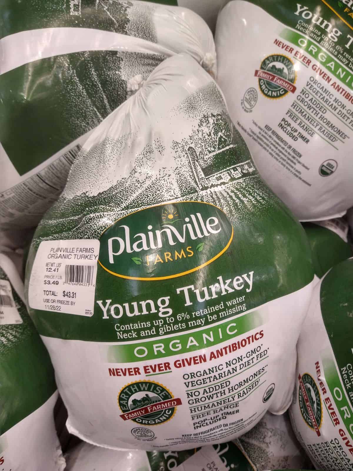 A display of Plainville Farms Young Organic Turkeys in green and white packaging at a Costco store.