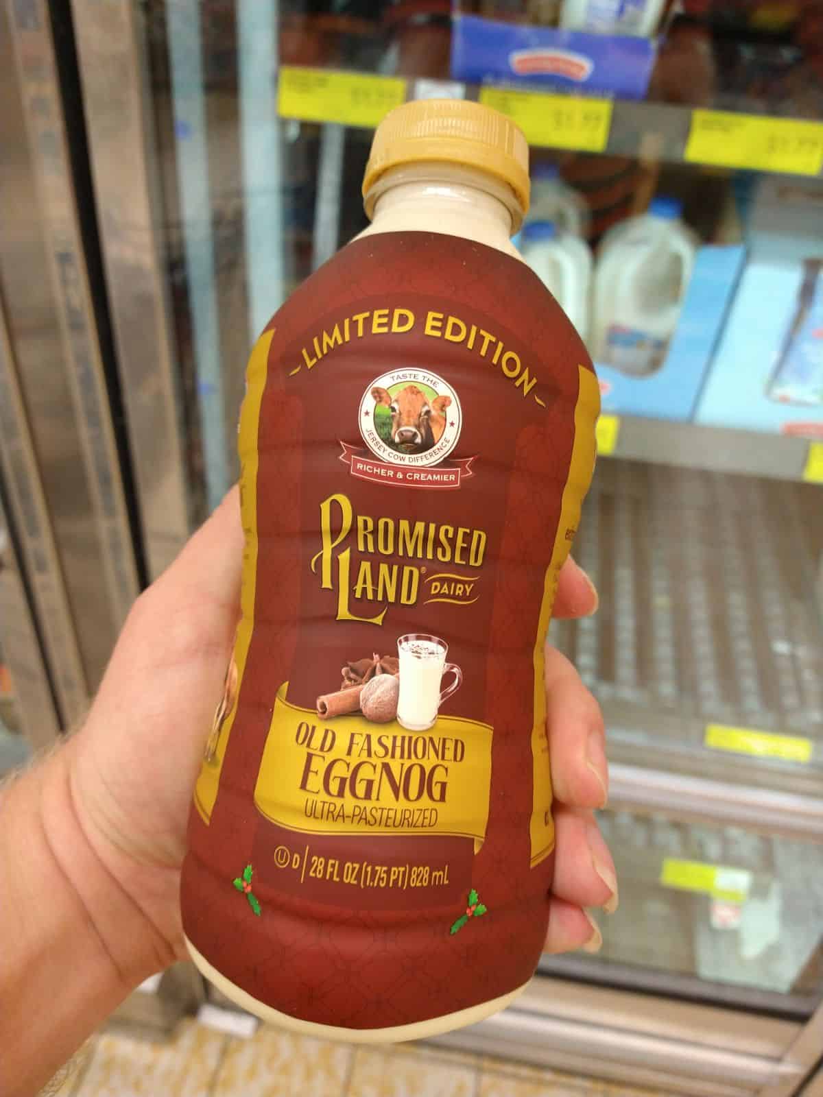 Holding a brown container of Promised Land Old Fashioned Egg Nog.