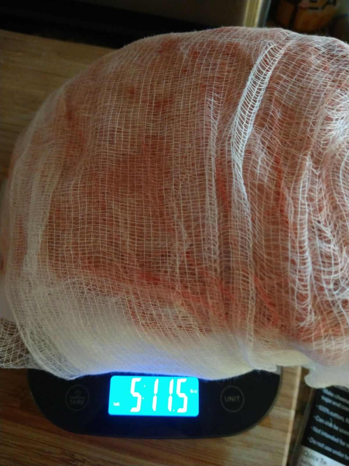 A cheesecloth wrapped standing rib roast on a scale showing it weighs 5 pounds 11.5 ounces.
