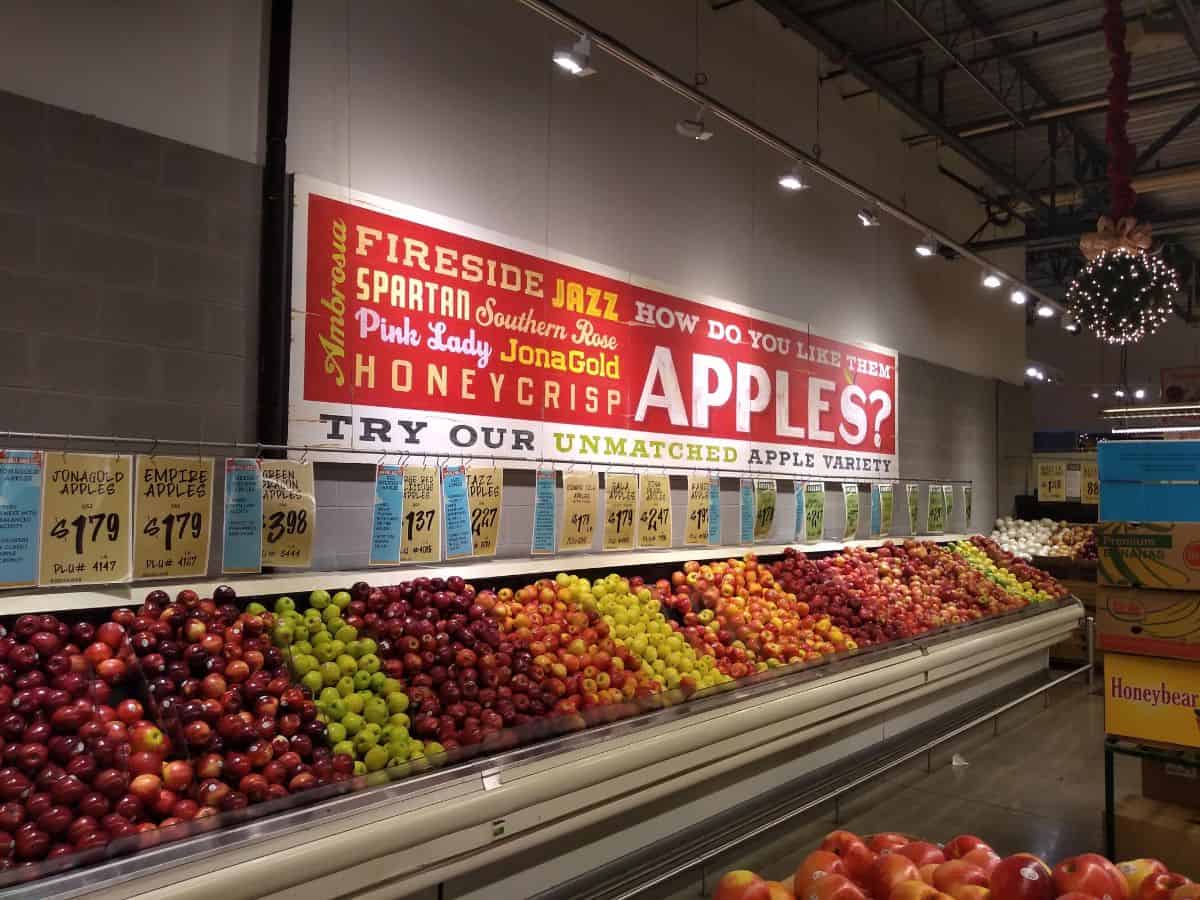 A sign at a grocery store listing different varieties of apples. Spartan is listed on the sign.