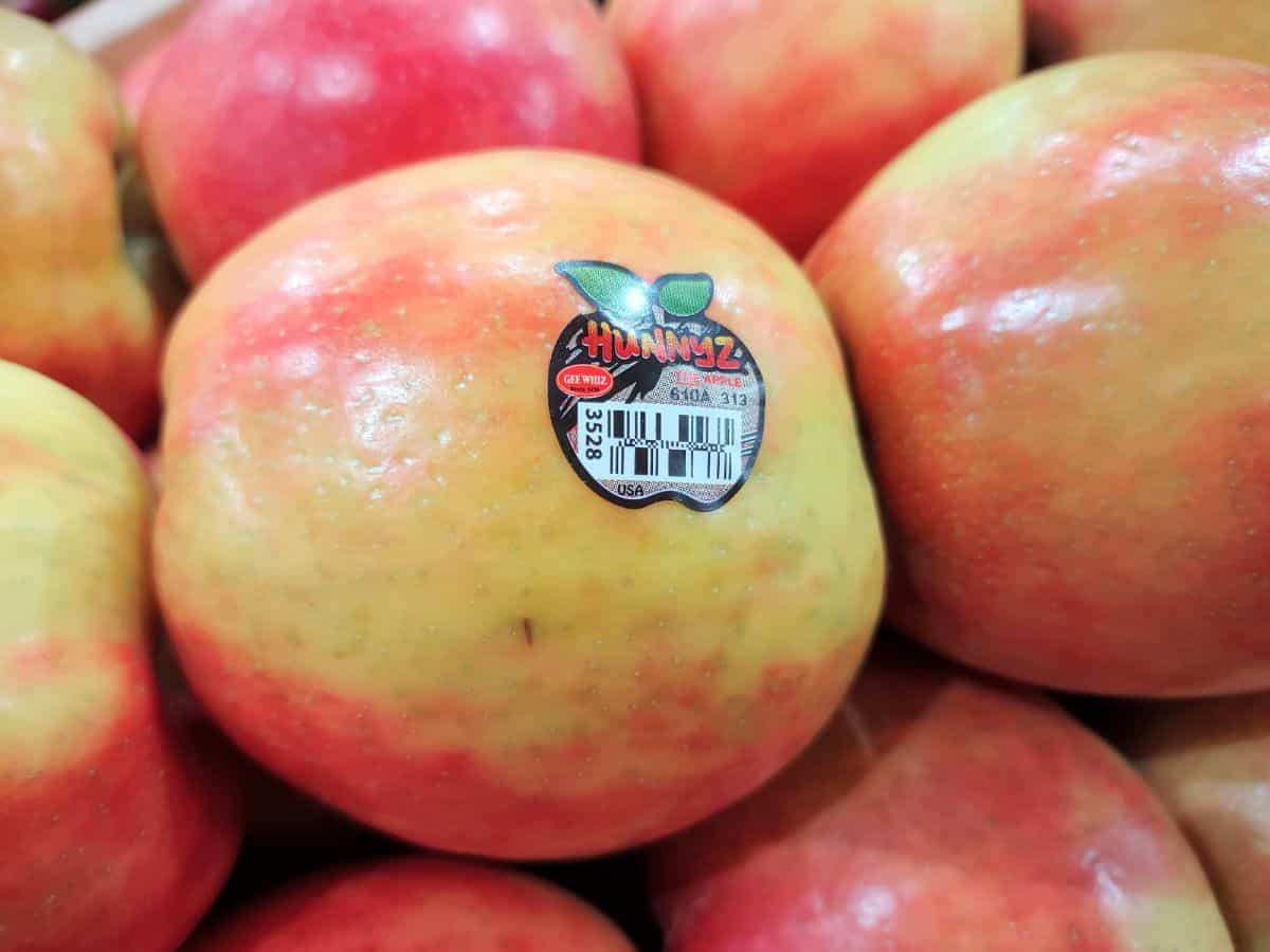 A display of Hunnyz apples stacked up at the grocery store.