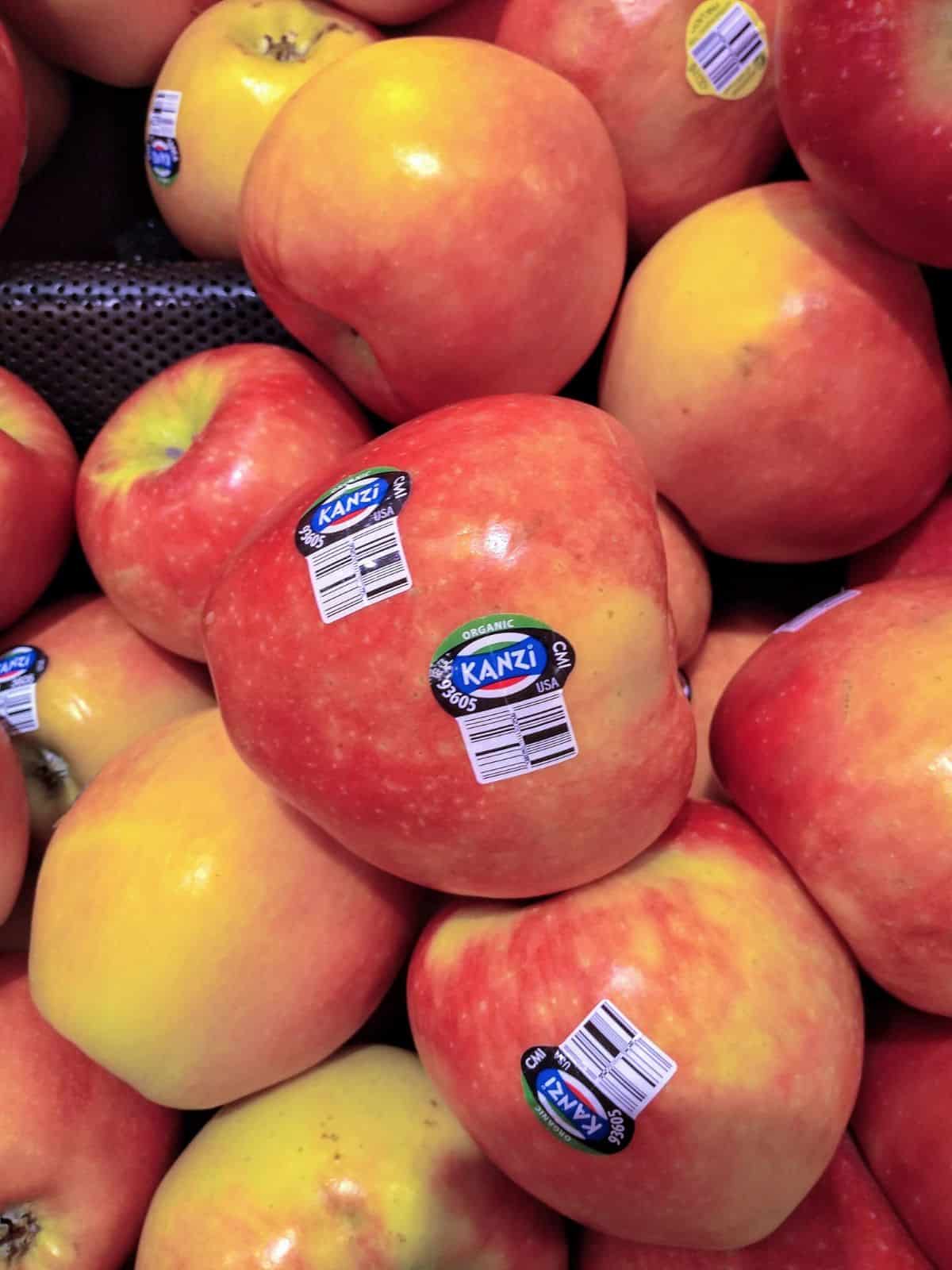 A close up of a display of Kanzi apples with the plu sticker of 93605.