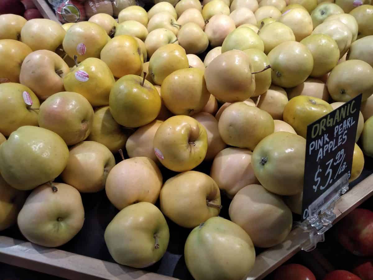 A display of organic pink pearl apples selling for $3.99/lb.