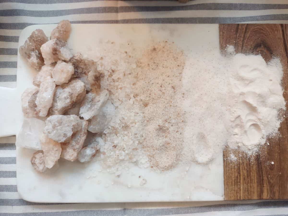 Different texture of slat from rocks to fine powder on a cutting board.