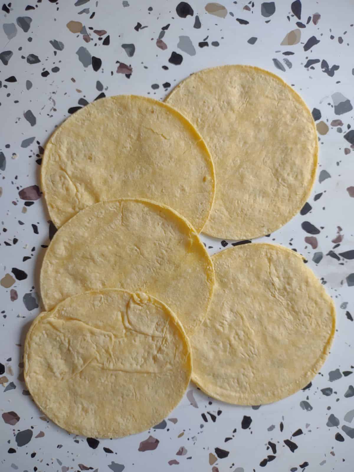 Soft corn tortillas on a table.