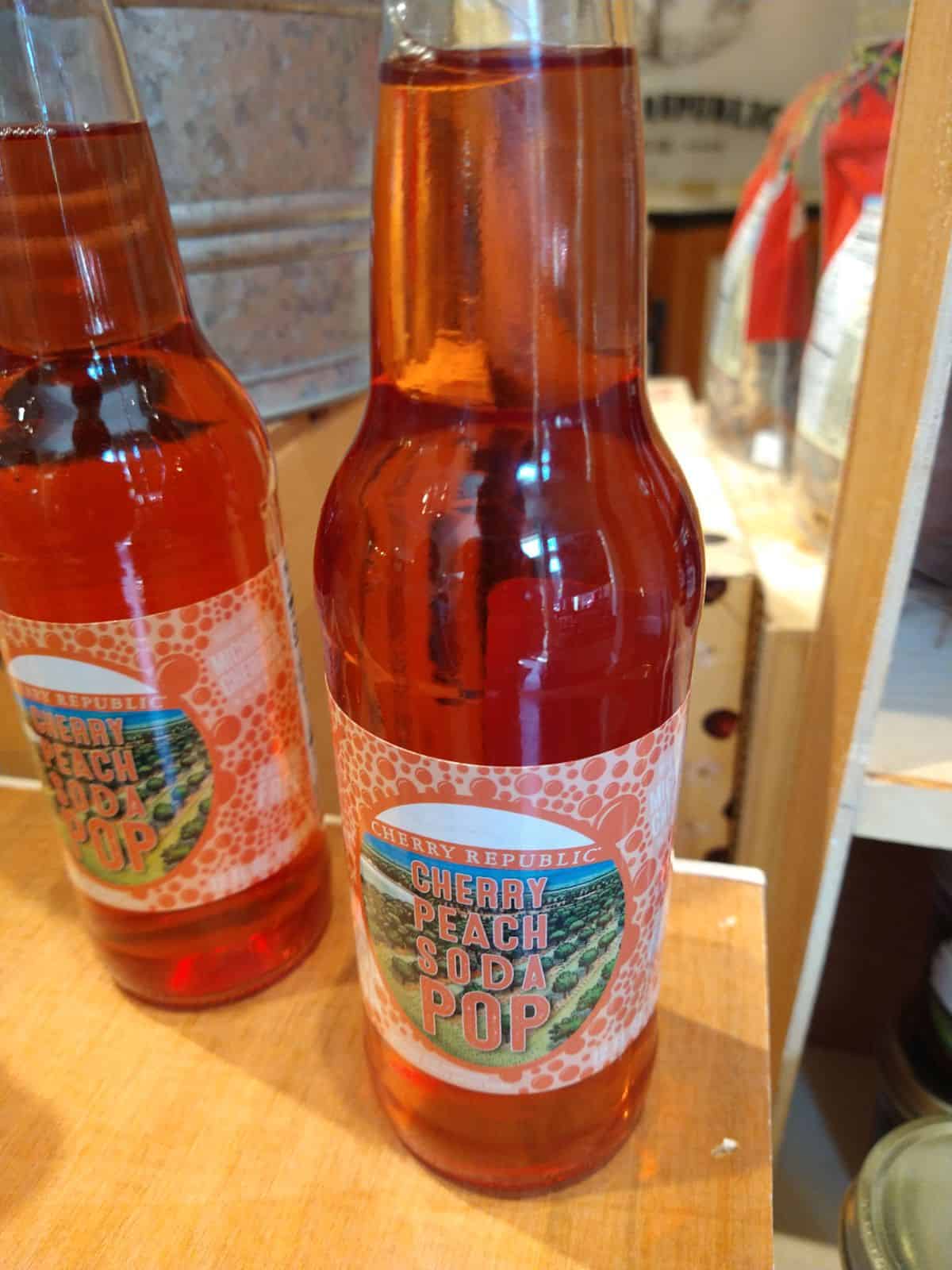 Bottles of Cherry Republic Cherry Peach Soda pop on a wood display.