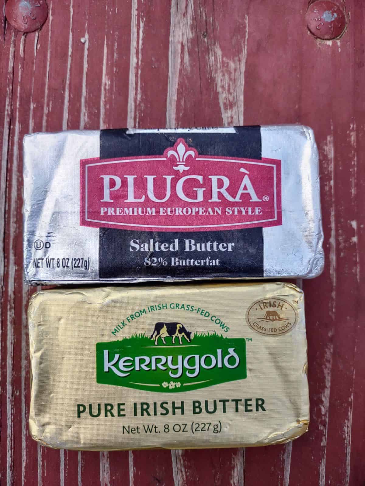 Plugra salted butter in gray foil above a Kerrygold salted butter in gold foil.