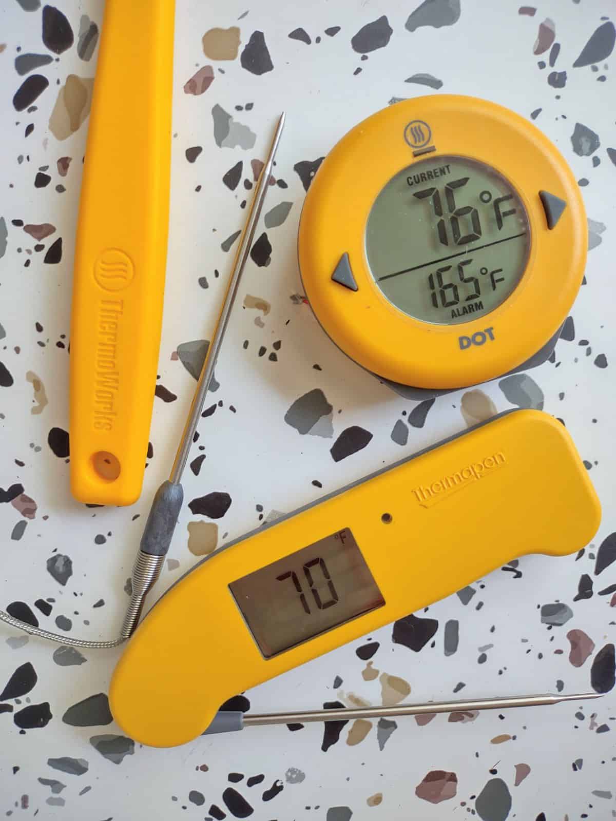 Thermworks products on a white table including a Thermapen One and a DOT probe thermometer.