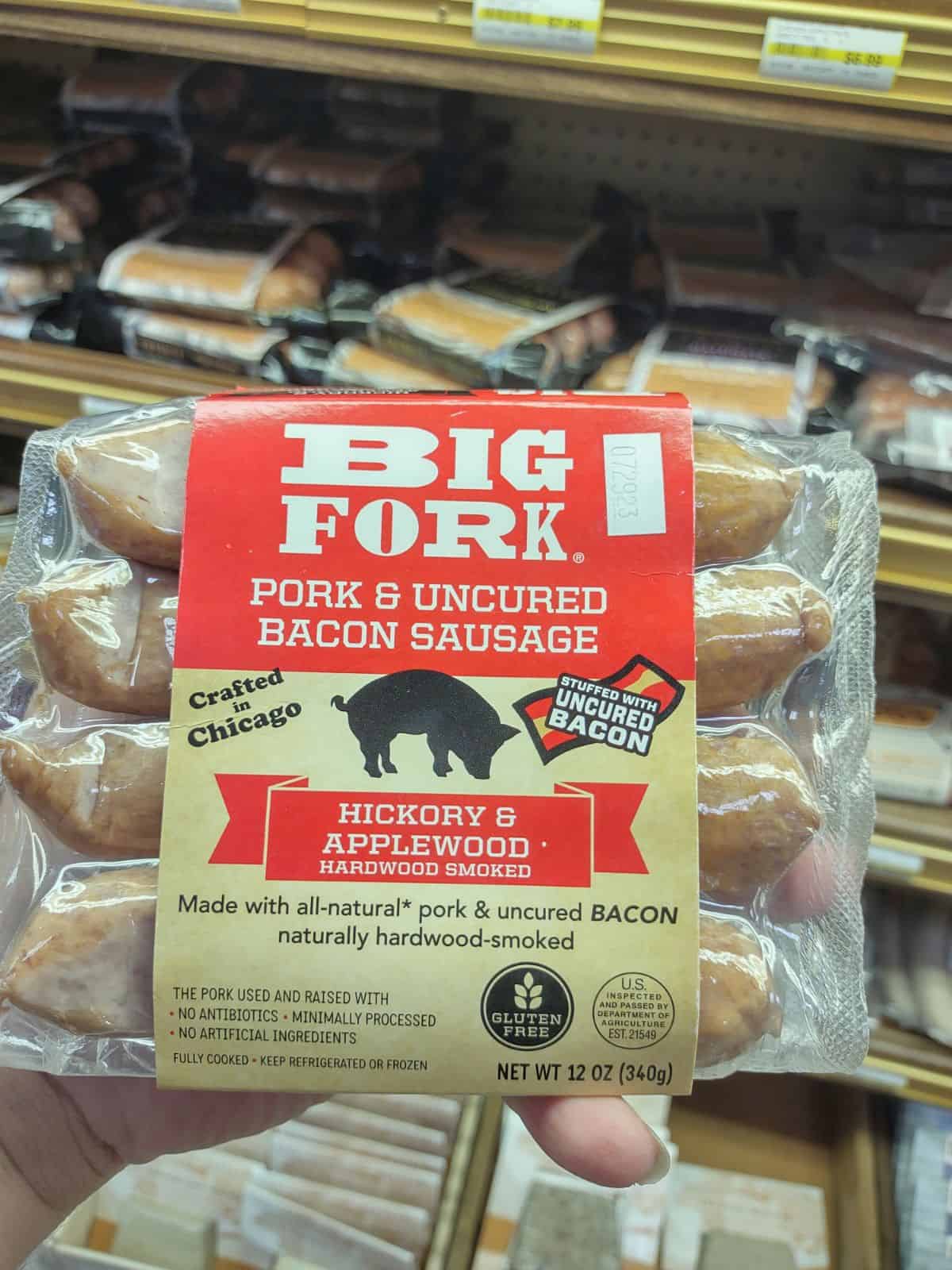 Holding up a package of Pork Fork Pork & Uncured Bacon Sausage