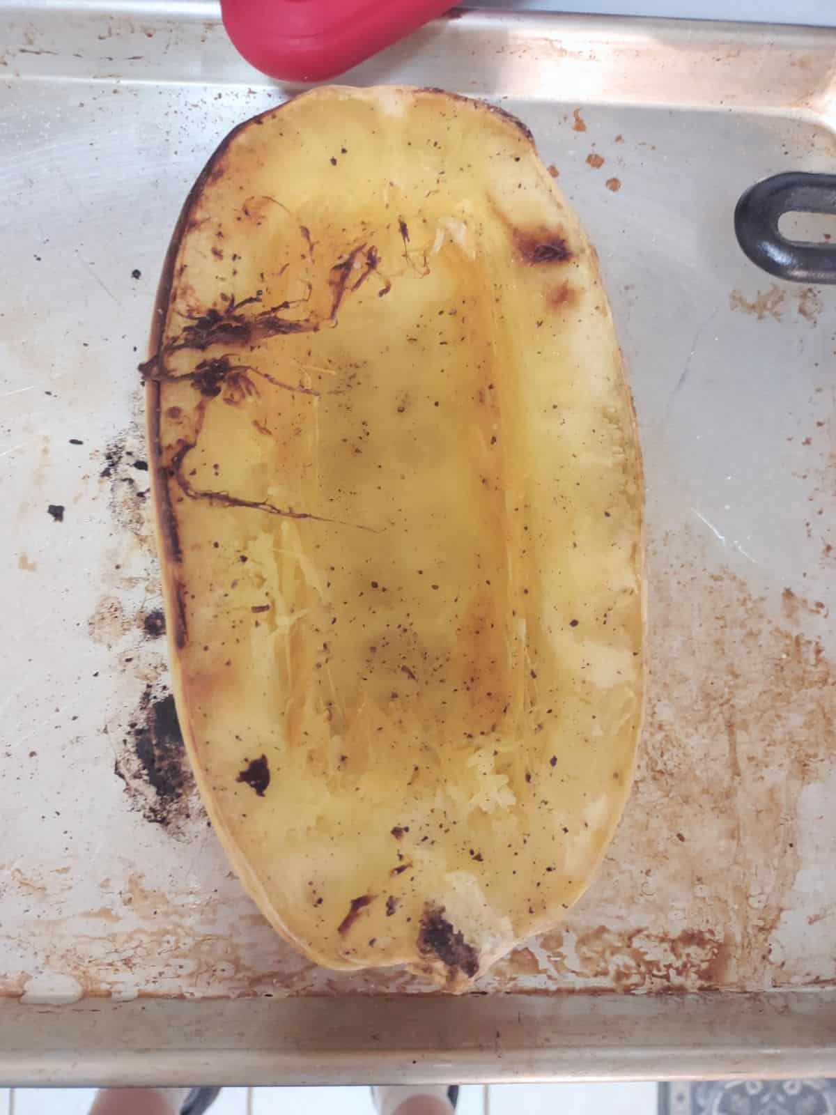 A half of a spaghetti squash on a sheet pan.