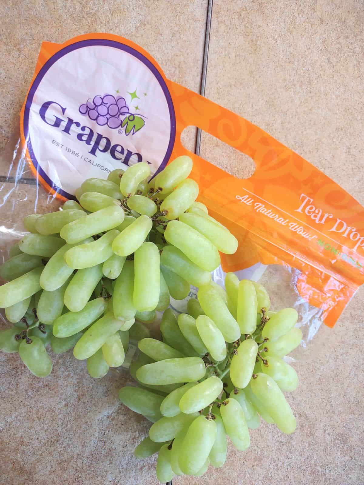 Green elongated Tear Drops grapes on top of the bag.