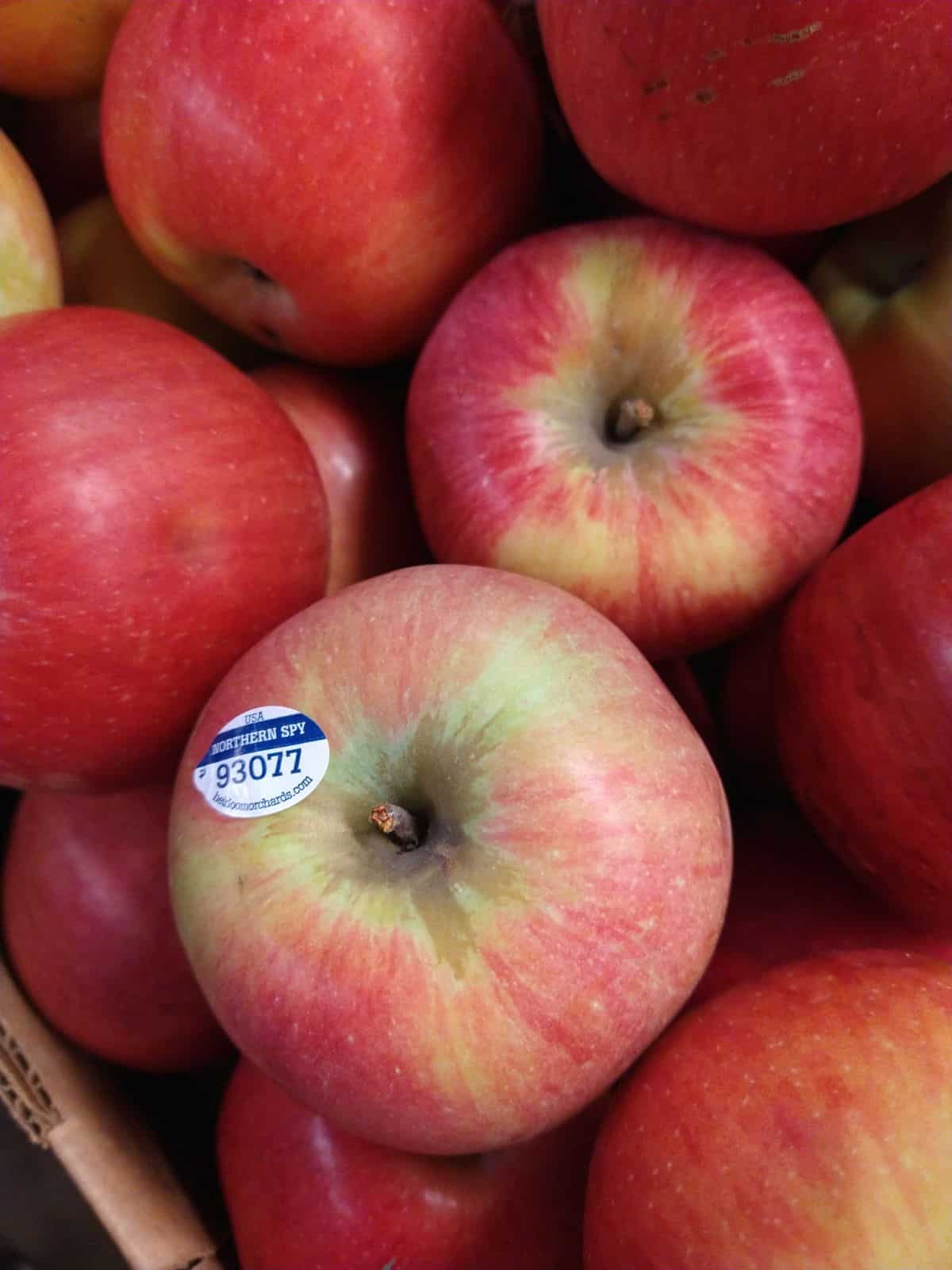 Northern Spy apples in box with PLU sticker on them.