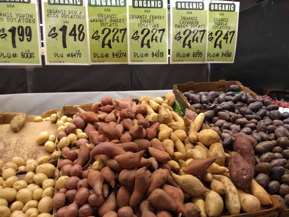 A display of different types and colors of sweet potatoes at a Central Market store.