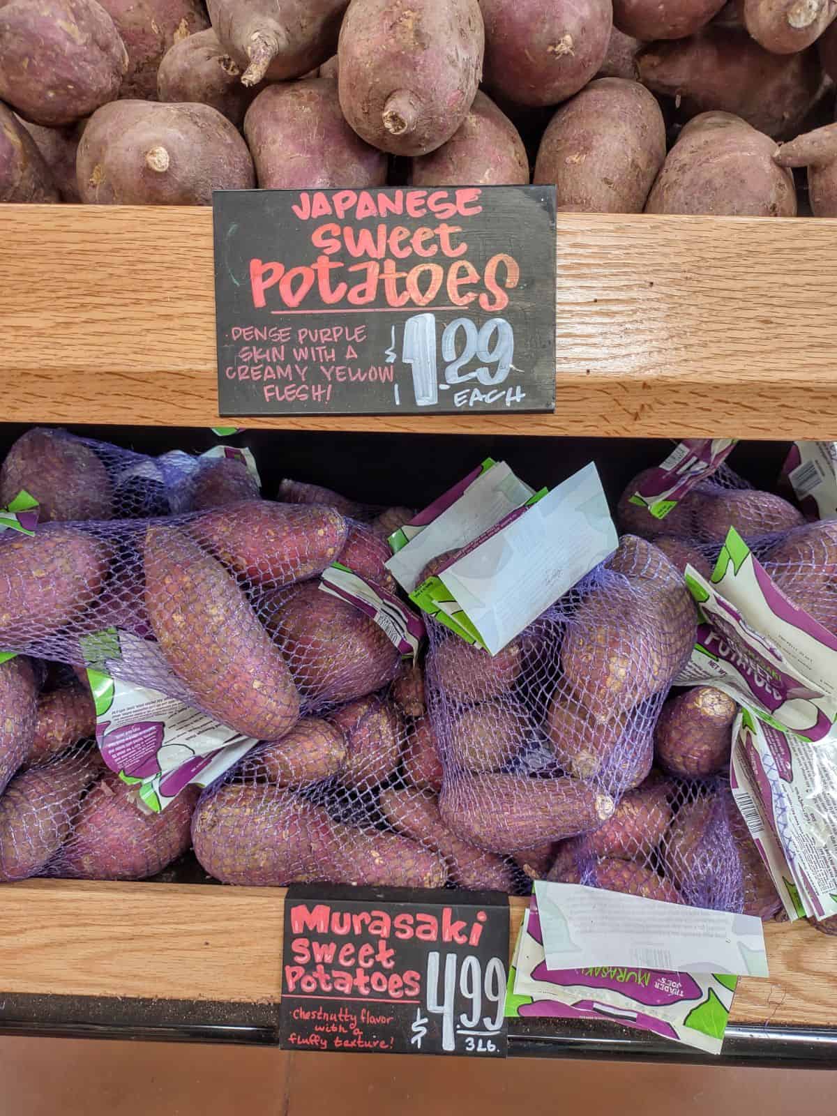 A Trader Joe's display with Japanese sweet potateos on top and Murasaki sweet potatoes in bags on the bottom.