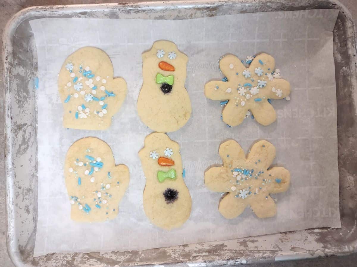 Cooked sugar cookies on a sheet pan with parchment paper. 