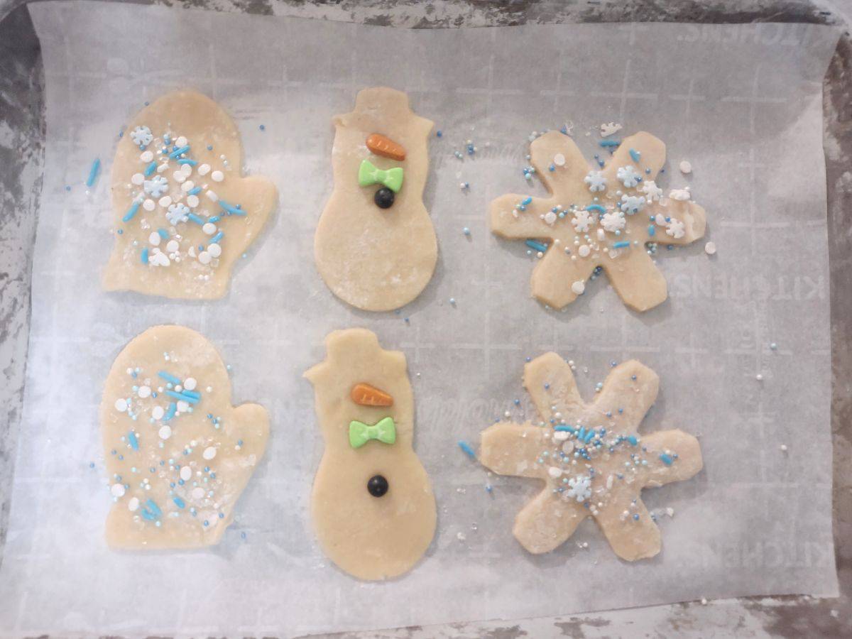 Raw sugar cookies on a sheet pan with parchment paper. 
