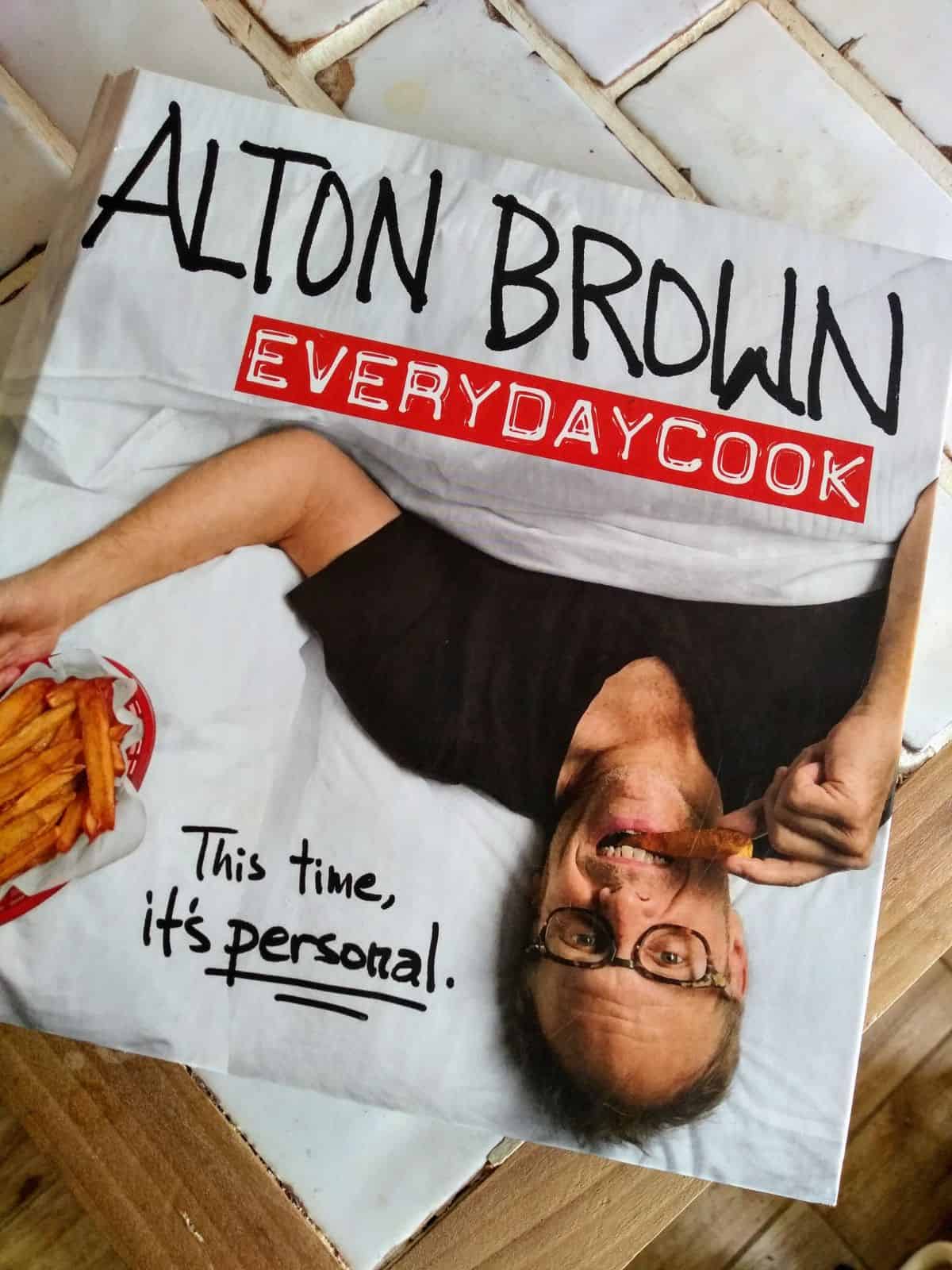 The book Alton Brown EveryDay Cook on a table.