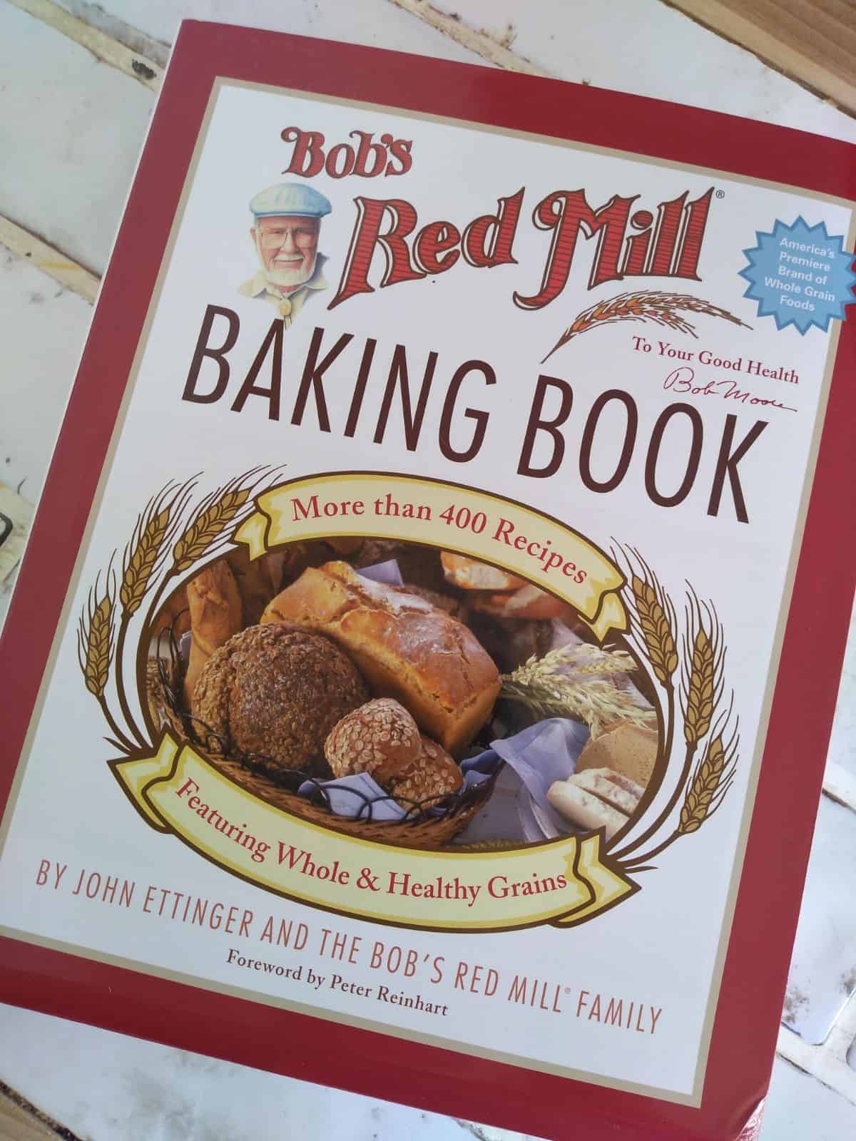 Bob's Red Mill Baking Book sitting on a white tile countertop.