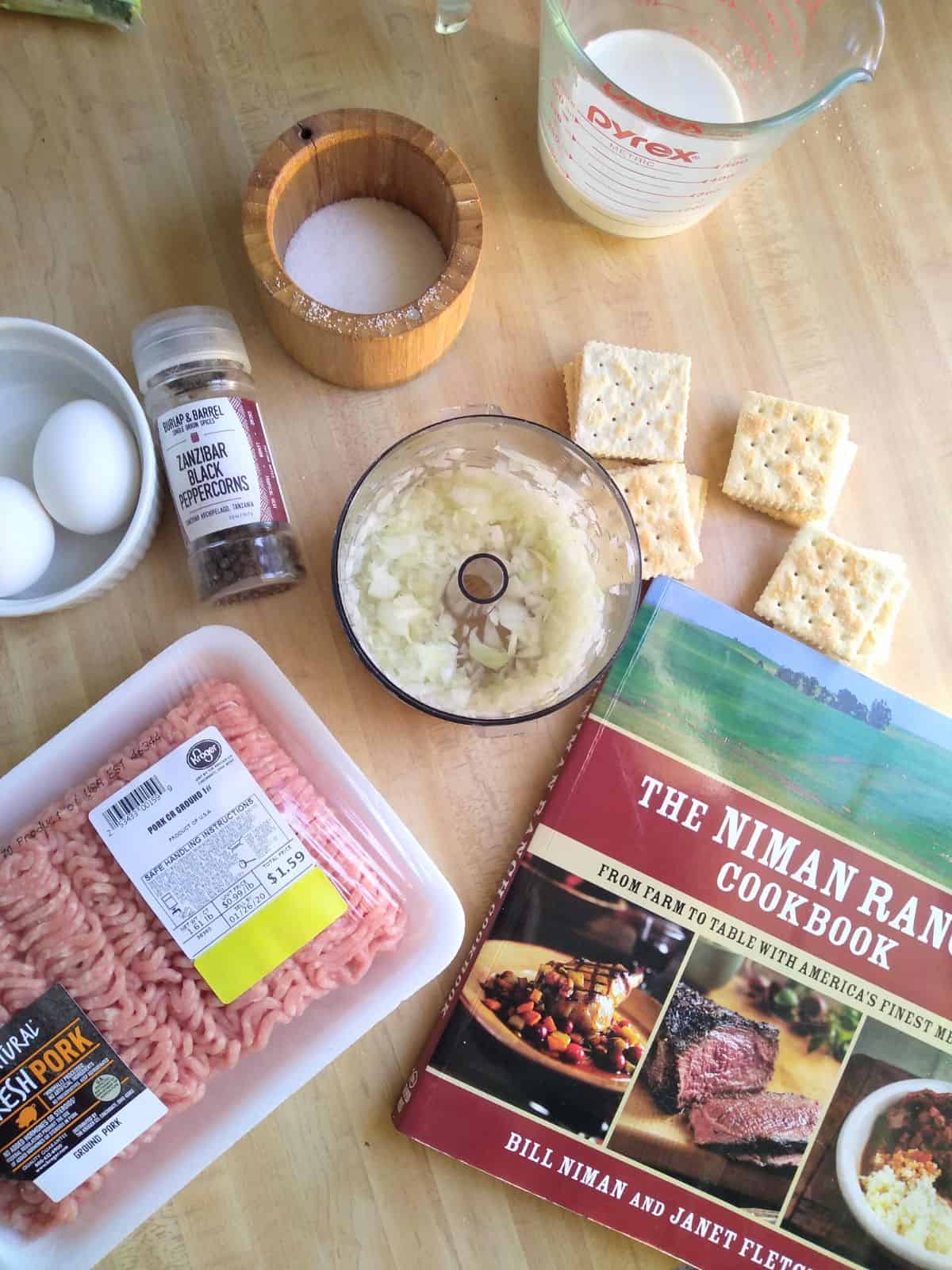 The ingredients for a pork burger with saltine crackers along with the Niman Ranch cookbook.