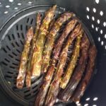 Purple asparagus that has been cooked in the air fryer so it has faded in color.