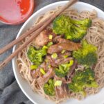 An Asian Inspired Pot Roast coated in a sauce from the cooking liquid with broccoli, over soba noodles and serve with sweet chili sauce.