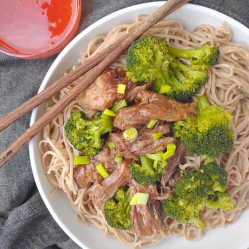 An Asian Inspired Pot Roast coated in a sauce from the cooking liquid with broccoli, over soba noodles and serve with sweet chili sauce.