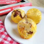 3 egg bites on a plate that contain chicken sausage.