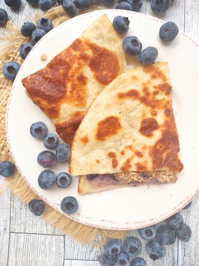 Blueberry Cheesecake Quesadillas on a plate with fresh blueberries.