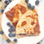 Blueberry Cheesecake Quesadillas on a plate with fresh blueberries.