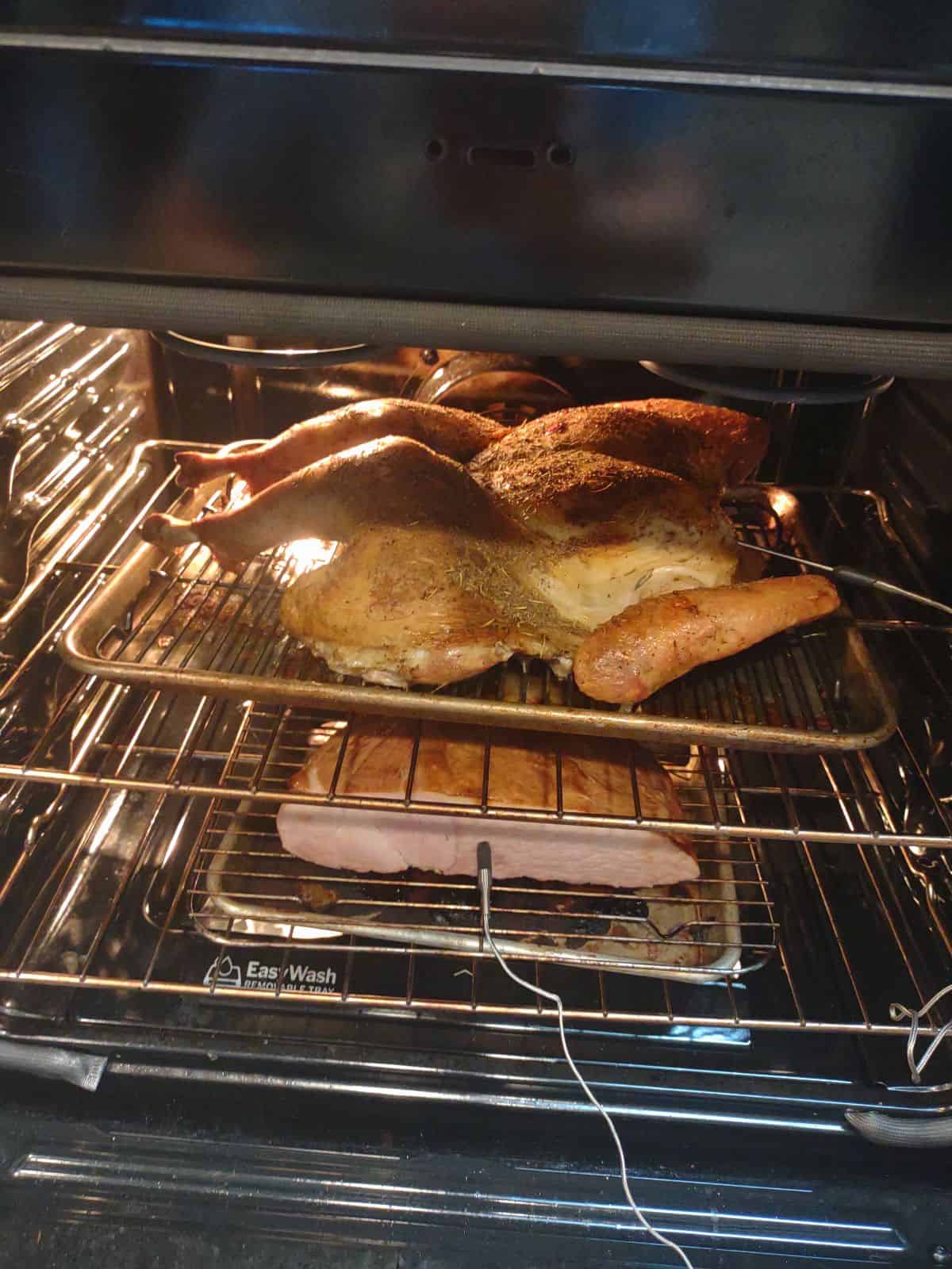 Spatchcocked turkey on the top rack of the oven with a Master Carve ham on the bottom rack.