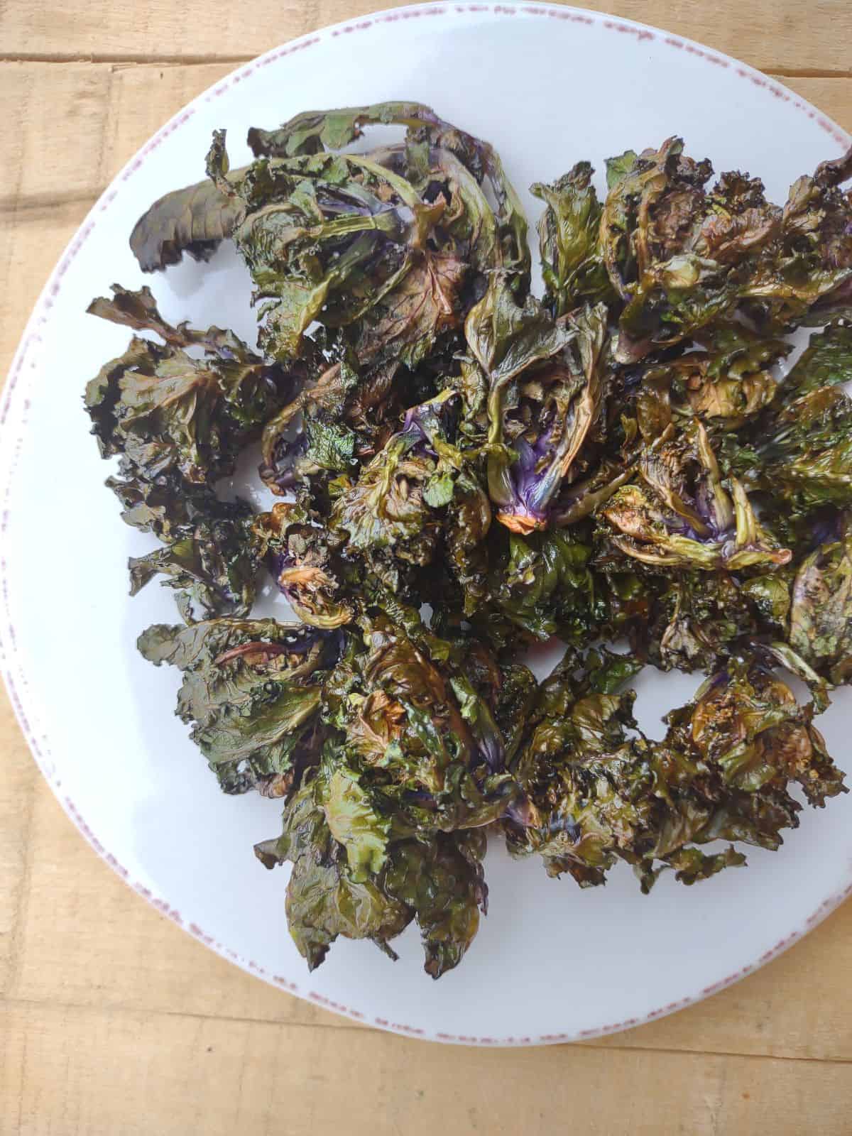 Crispy Air fried Green and Purple Kalettes on a white plate