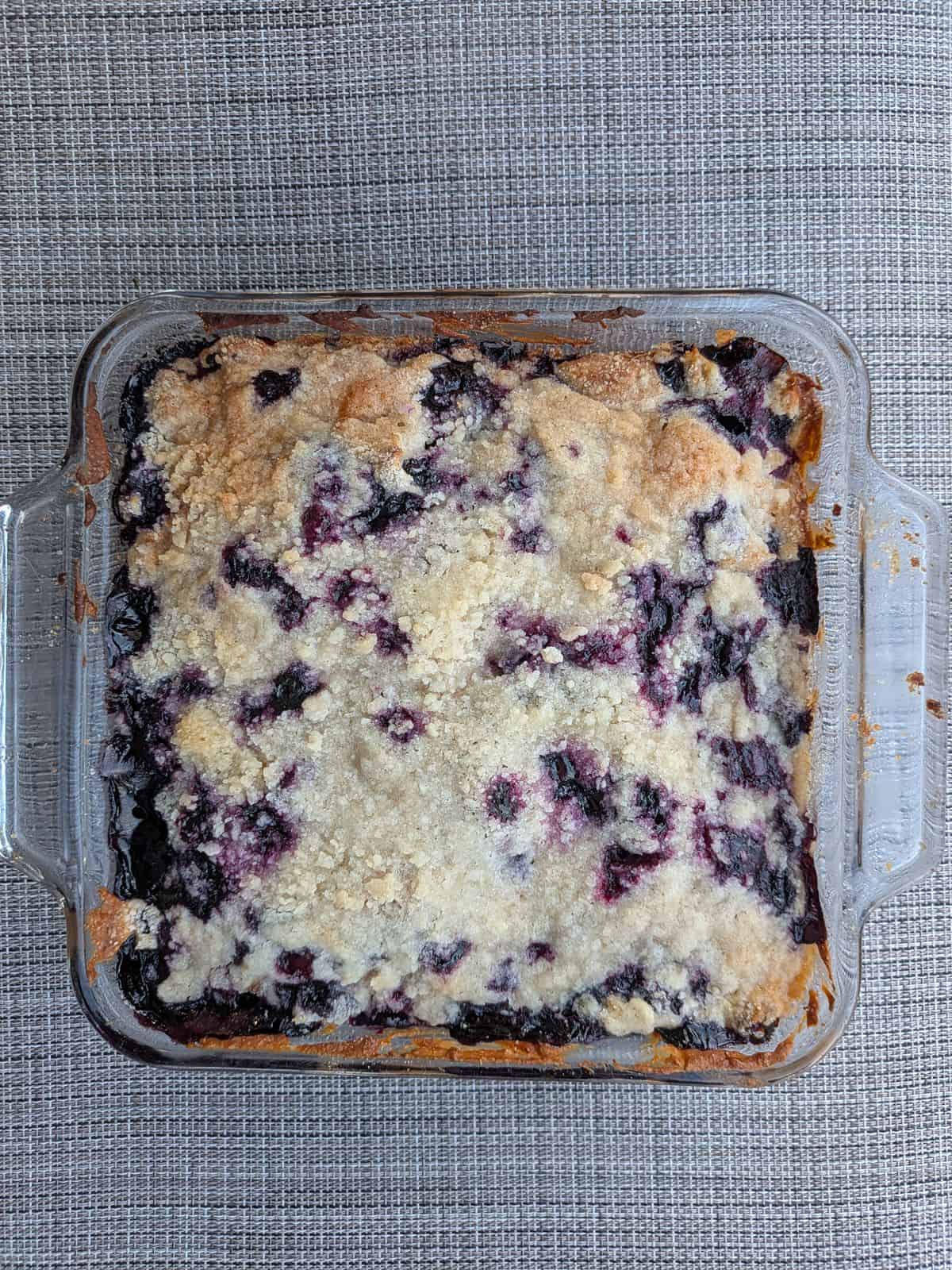 An overhead view of Alton Brown's Blueberry Buckle in a glass baking dish