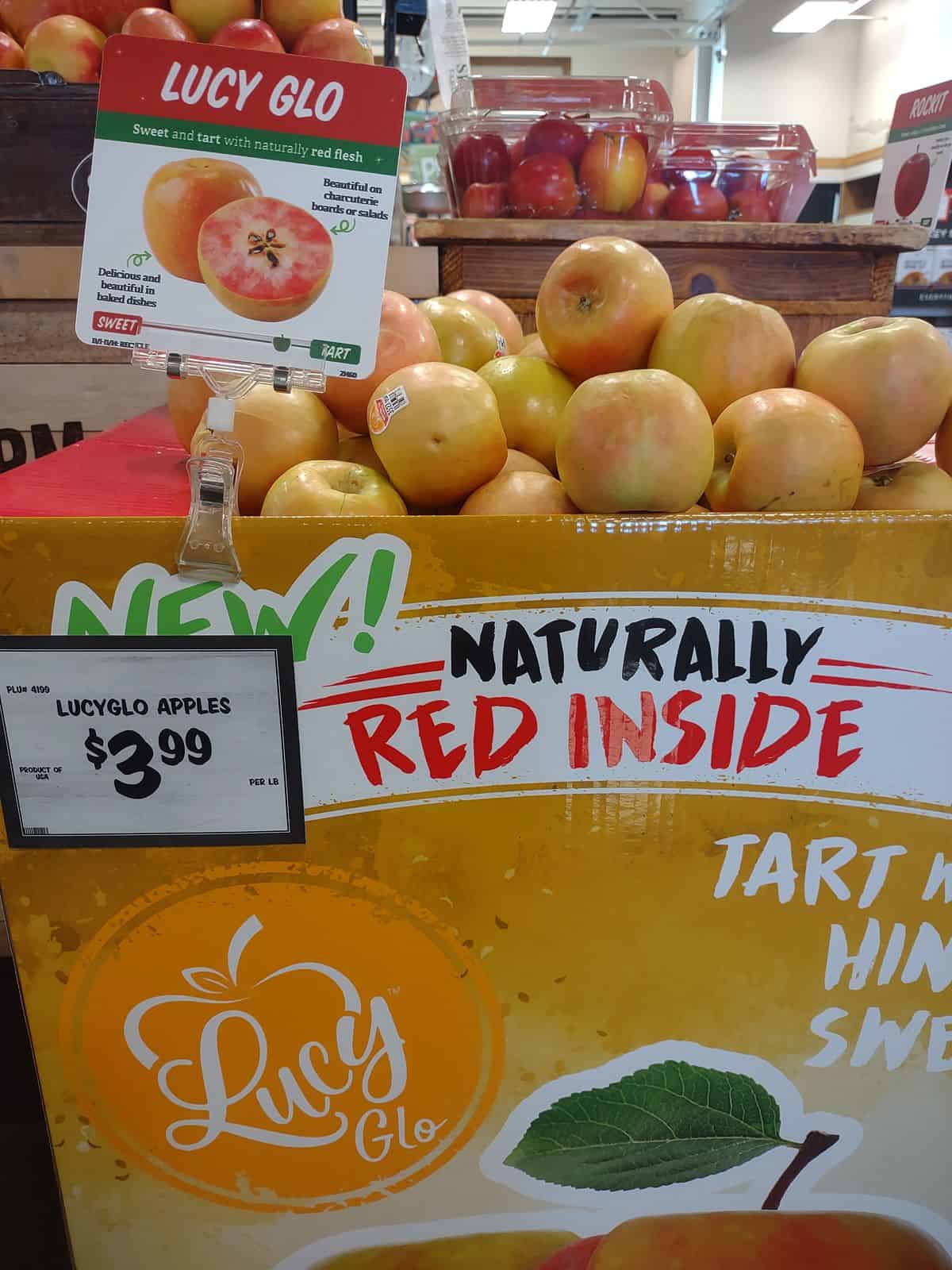 A display at a Sprouts store featuring marketing materials for the Lucy Glo apple.